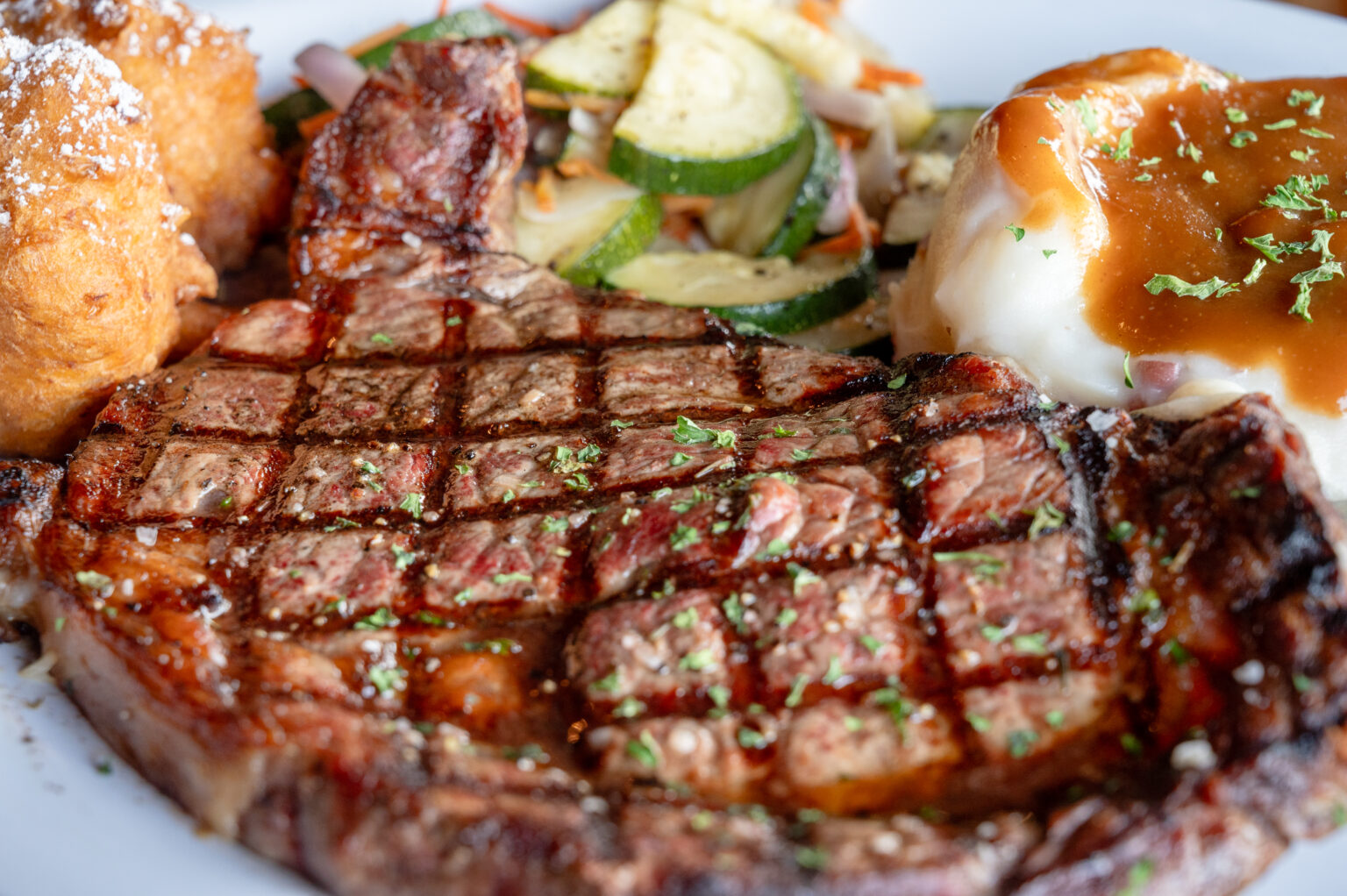 Friendly Fisherman Steak and mashed potatos with salad and hush puppies
